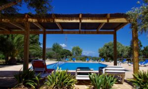 Großzügige Poolterrasse mit Sonnenliegen und Beschattung